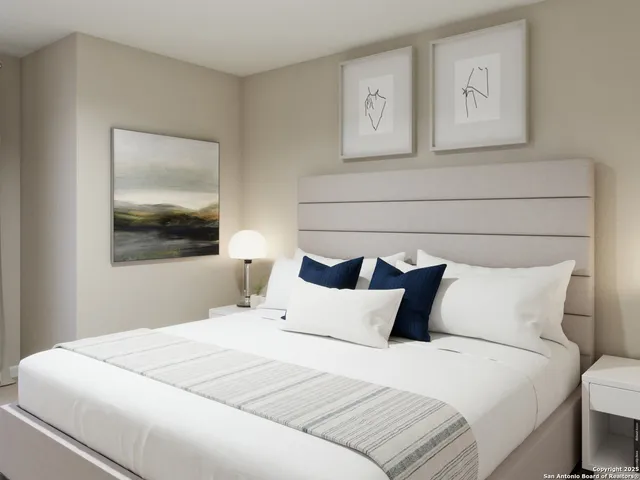 a bedroom with a large bed and a potted plant