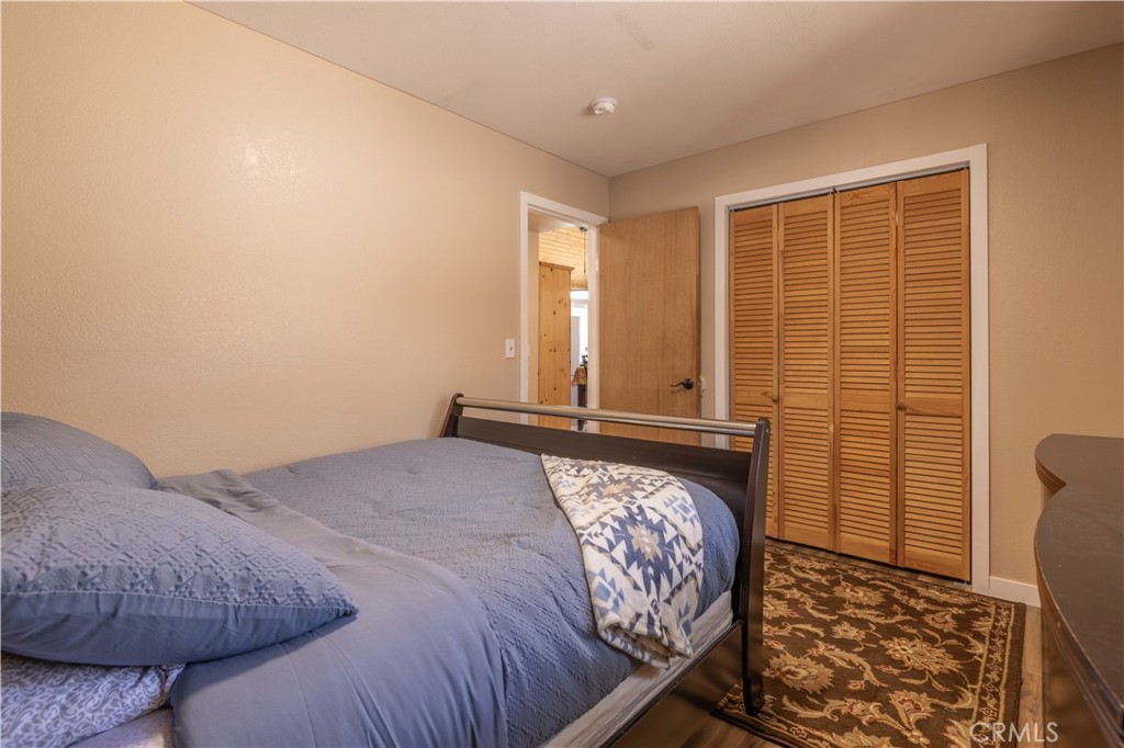196 Sunset Lane Sugarloaf, CA 92386 - Photo 11 of 26 a bedroom with a bed and wooden floor
