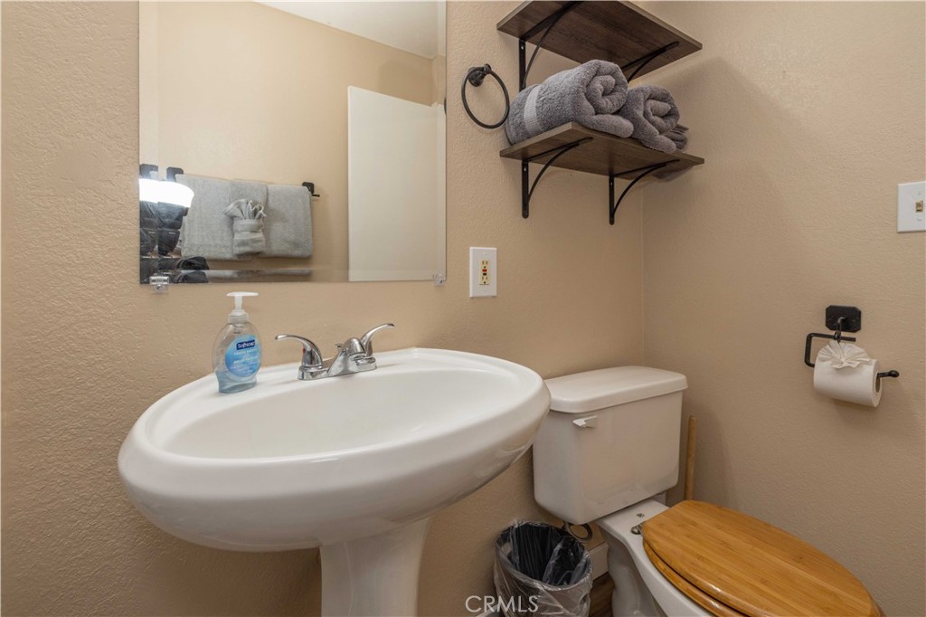 196 Sunset Lane Sugarloaf, CA 92386 - Photo 15 of 26 a bathroom with a toilet a sink and mirror