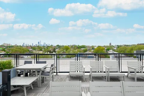 a roof deck with table and chairs
