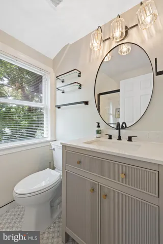a bathroom with a toilet a sink and mirror