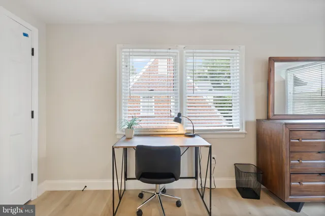 a view of a workspace with furniture and a window