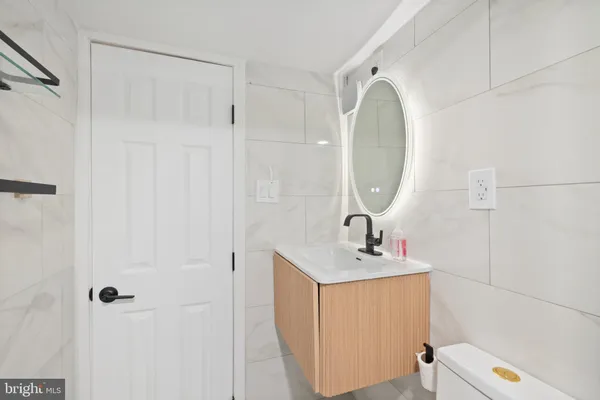 a bathroom with a sink a toilet and a mirror