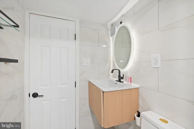 a bathroom with a sink a toilet and a mirror