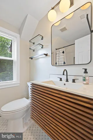 a bathroom with a sink a toilet and mirror