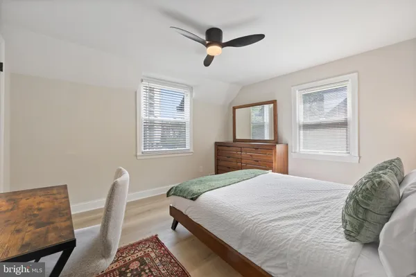 a bedroom with a large bed a chandelier and a window
