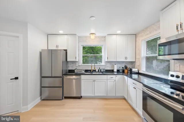 a kitchen with stainless steel appliances granite countertop a stove a refrigerator and a sink