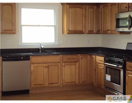 64 Helmetta Road Monroe Township, NJ 08831 - Photo 5 of 22 a kitchen with granite countertop a stove a sink and a microwave