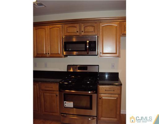 64 Helmetta Road Monroe Township, NJ 08831 - Photo 6 of 22 a kitchen with granite countertop white cabinets and black appliances