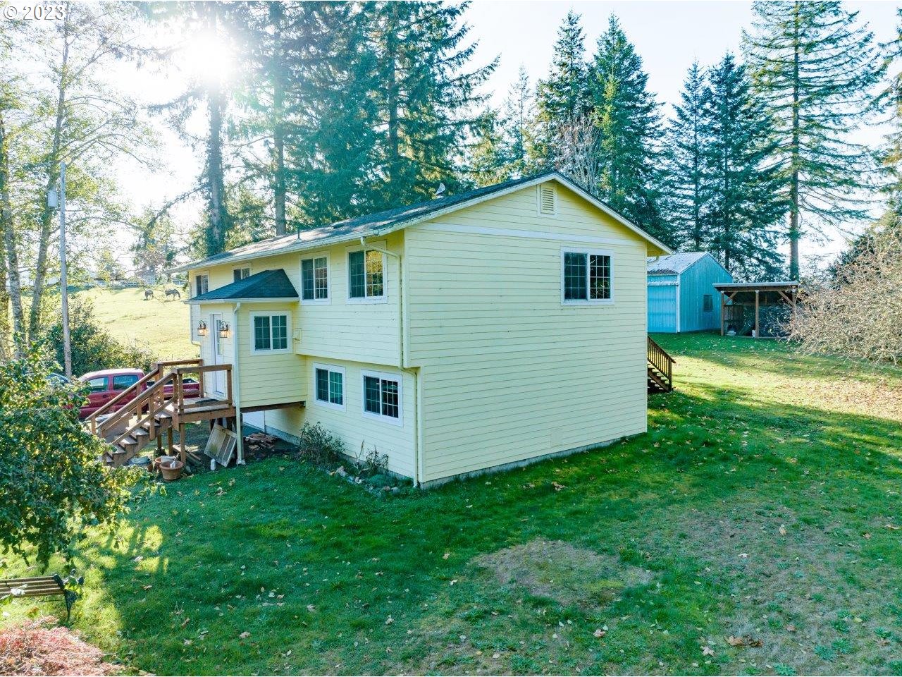 93066 Knappa Dock Road Astoria, OR 97103 - Photo 3 of 29 a view of backyard of house with wooden deck and large tree