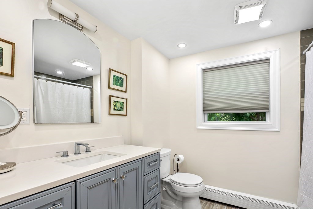 10 Colonial Road Hingham, MA 02043 - Photo 15 of 21 a bathroom with a granite countertop toilet a sink and mirror