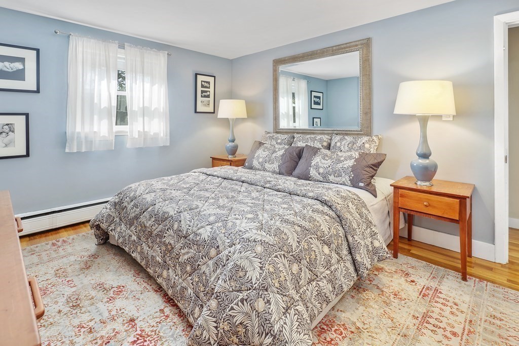 10 Colonial Road Hingham, MA 02043 - Photo 16 of 21 a bedroom with a bed and a lamp on table