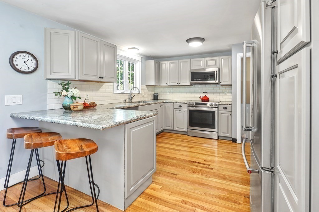 10 Colonial Road Hingham, MA 02043 - Photo 5 of 21 a kitchen with stainless steel appliances granite countertop a stove top oven a refrigerator a sink and dishwasher with white cabinets