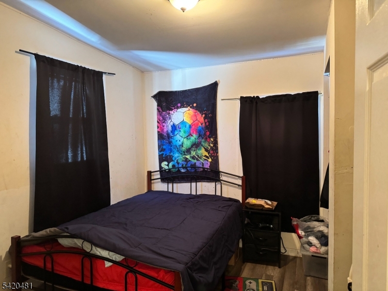 65 Stone Street Newark, NJ 07104 - Photo 13 of 37 a bedroom with a bed and a flat screen tv