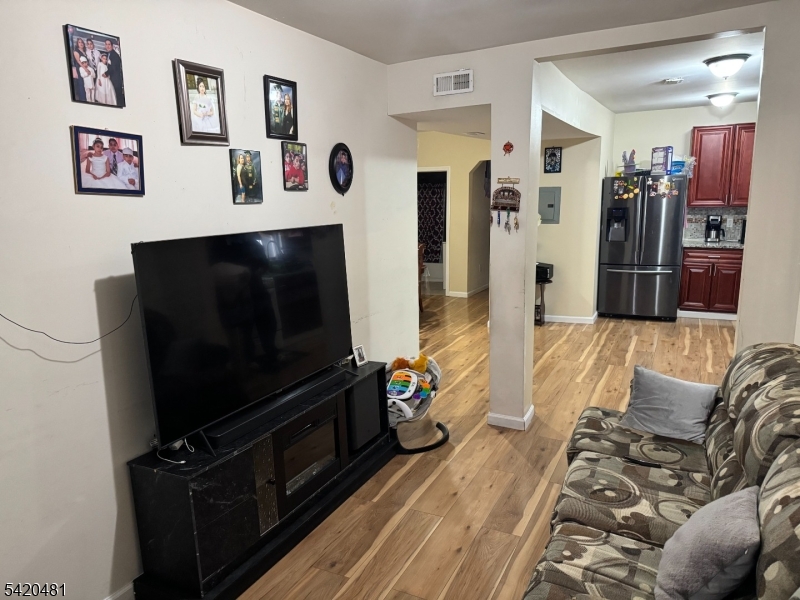65 Stone Street Newark, NJ 07104 - Photo 18 of 37 a living room with furniture and a flat screen tv