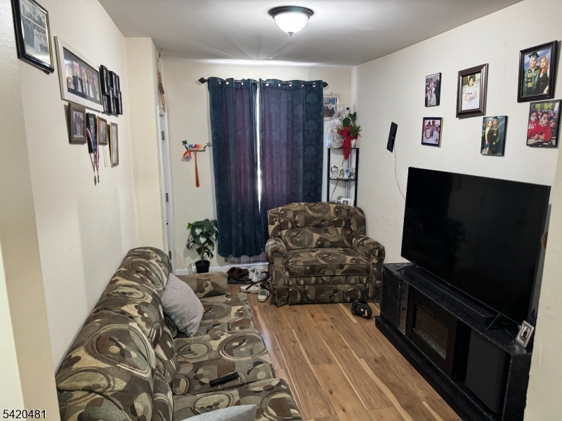 65 Stone Street Newark, NJ 07104 - Photo 19 of 37 a living room with furniture and a flat screen tv