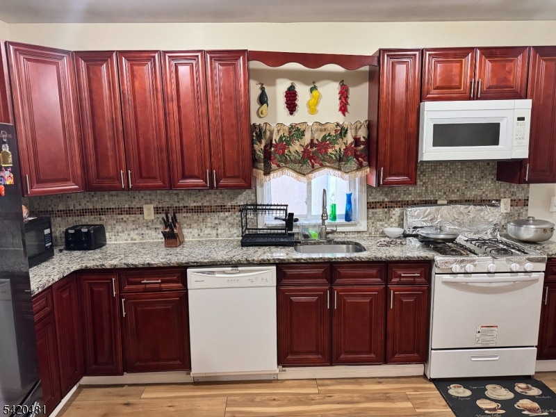 65 Stone Street Newark, NJ 07104 - Photo 22 of 37 a kitchen with stainless steel appliances granite countertop a stove a sink and a microwave