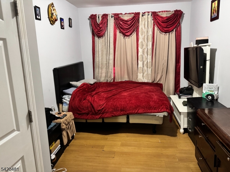 65 Stone Street Newark, NJ 07104 - Photo 26 of 37 a bedroom with a bed and a flat tv screen on the dresser