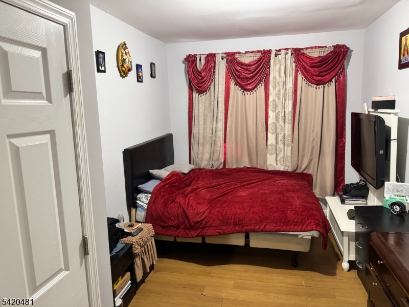 65 Stone Street Newark, NJ 07104 - Photo 27 of 37 a bedroom with a bed and a flat screen tv