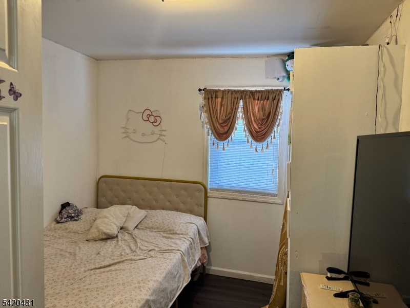 65 Stone Street Newark, NJ 07104 - Photo 29 of 37 a bedroom with a bed and a refrigerator