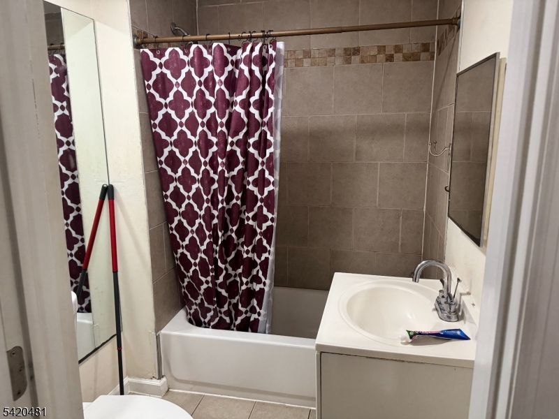 65 Stone Street Newark, NJ 07104 - Photo 34 of 37 a bathroom with a sink and a mirror
