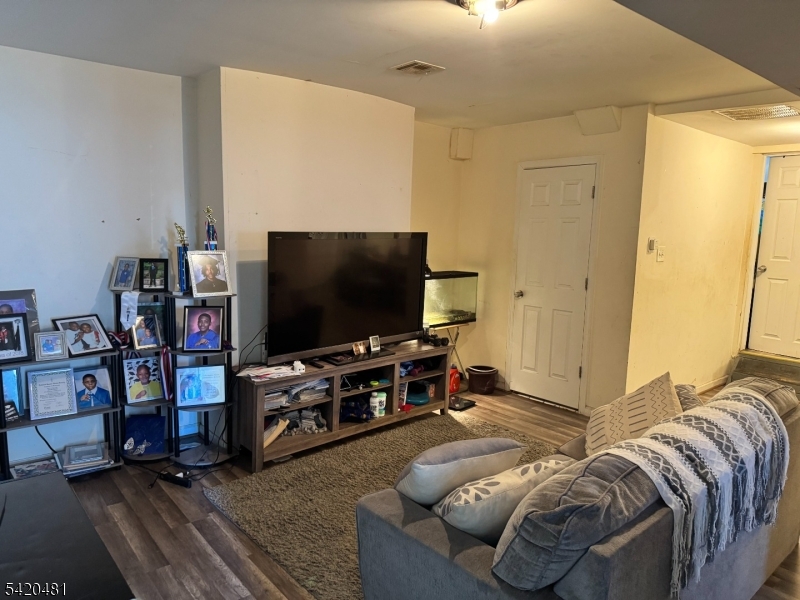 65 Stone Street Newark, NJ 07104 - Photo 8 of 37 a living room with furniture and a flat screen tv