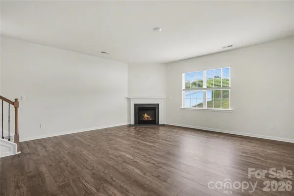 a view of an empty room with a fireplace and a window