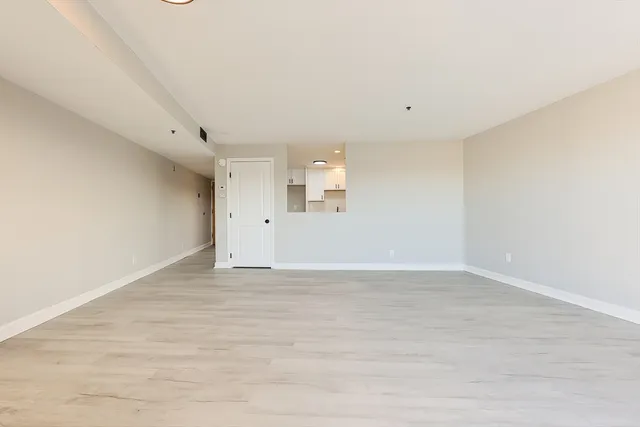 a view of an empty room with wooden floor