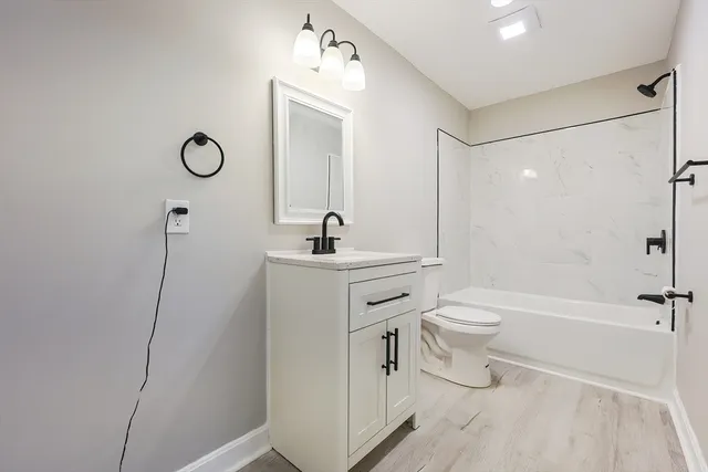 a bathroom with a sink a toilet a mirror and shower