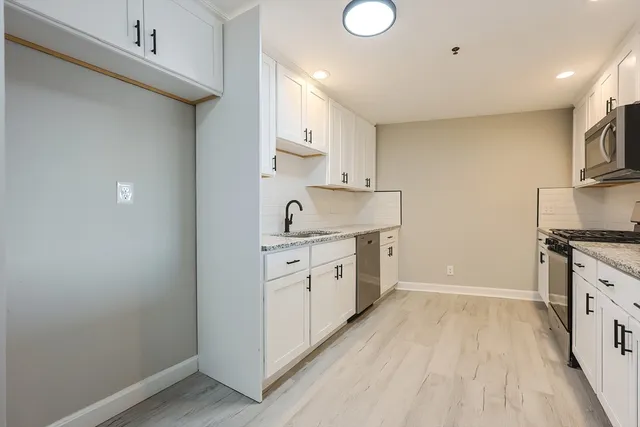 a kitchen with cabinets wooden floor and a sink