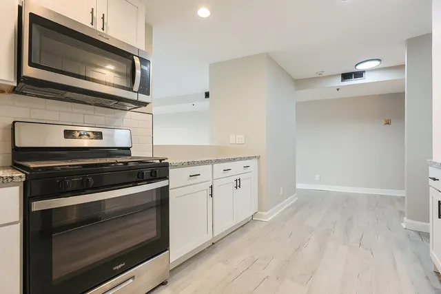 a kitchen with stainless steel appliances a stove microwave and cabinets