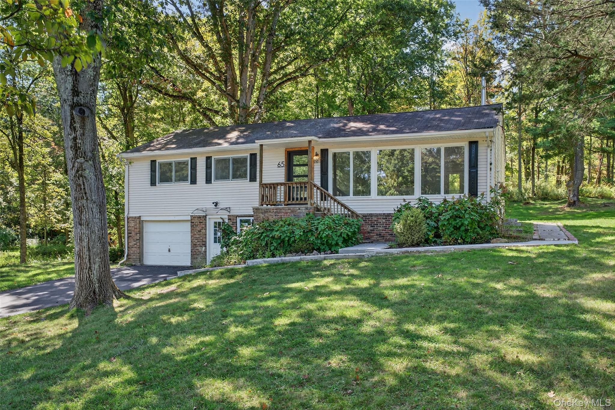 65 Hawxhurst Road Monroe, NY 10950 - Photo 2 of 35 View of front of home with brick siding, a front lawn, a garage, and driveway