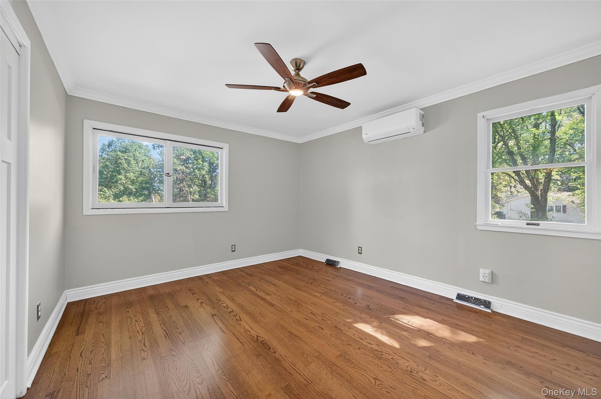 65 Hawxhurst Road Monroe, NY 10950 - Photo 23 of 35 Empty room featuring crown molding, wood finished floors, ceiling fan, and a wall mounted air conditioner