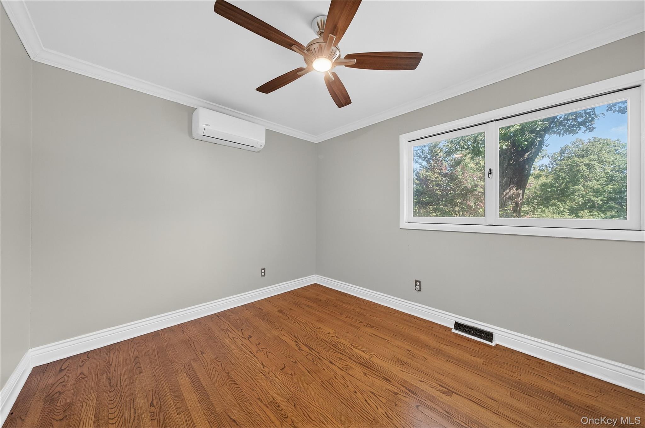 65 Hawxhurst Road Monroe, NY 10950 - Photo 24 of 35 Empty room featuring crown molding, wood finished floors, ceiling fan, and an AC wall unit