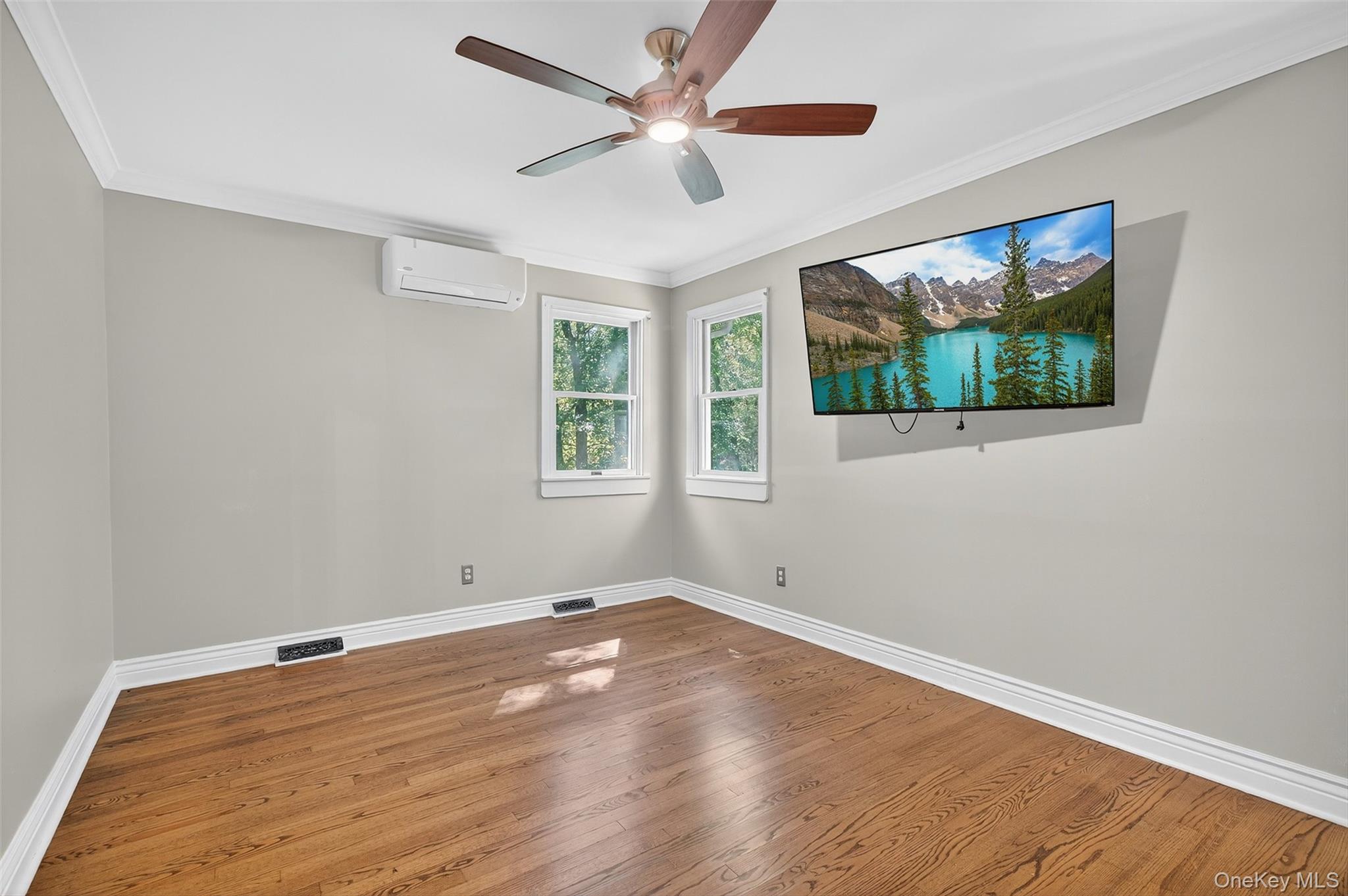 65 Hawxhurst Road Monroe, NY 10950 - Photo 25 of 35 Unfurnished room with crown molding, wood finished floors, ceiling fan, and a wall mounted AC