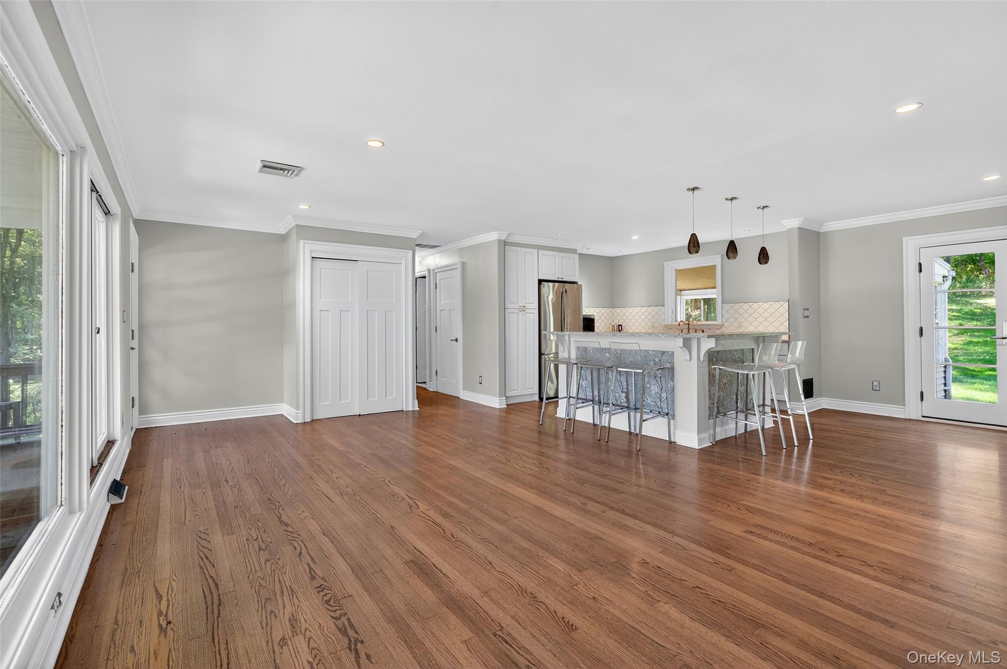 65 Hawxhurst Road Monroe, NY 10950 - Photo 10 of 35 Unfurnished living room featuring plenty of natural light, crown molding, dark wood-type flooring, and recessed lighting