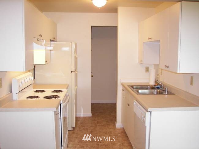 3909 Mason Loop Road Tacoma, WA 98409 - Photo 3 of 7 a kitchen that has a sink a stove and a refrigerator