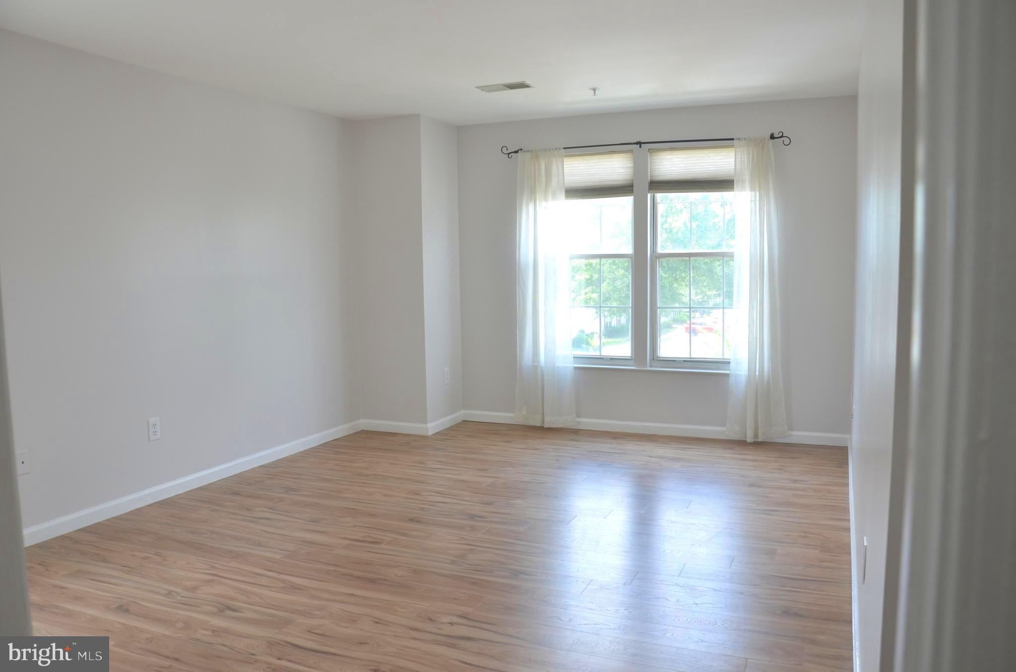7522 Snowpea Court, Unit 24 Alexandria, VA 22306 - Photo 13 of 19 a view of an empty room with wooden floor and a window