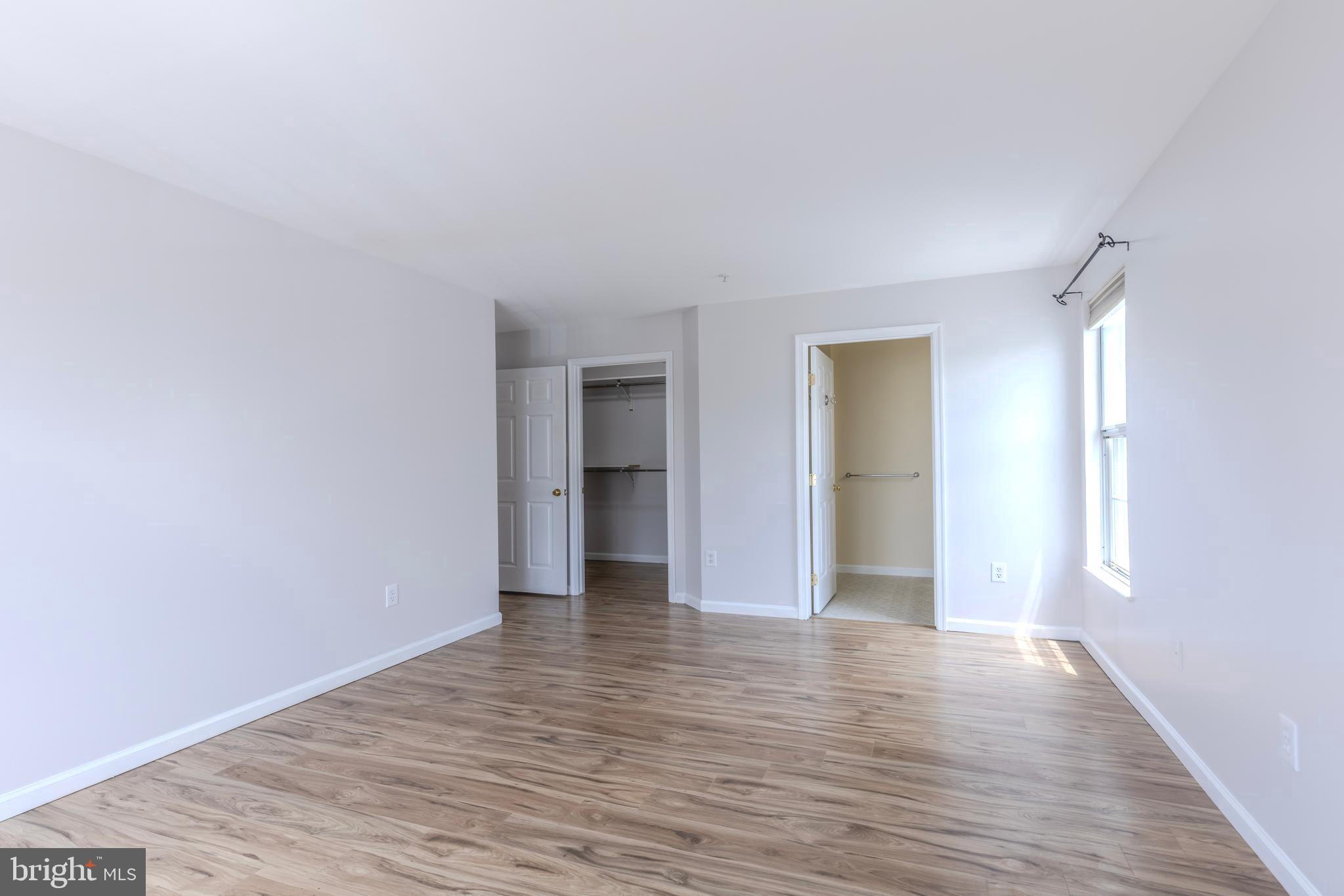 7522 Snowpea Court, Unit 24 Alexandria, VA 22306 - Photo 15 of 19 a view of an empty room with wooden floor and a window