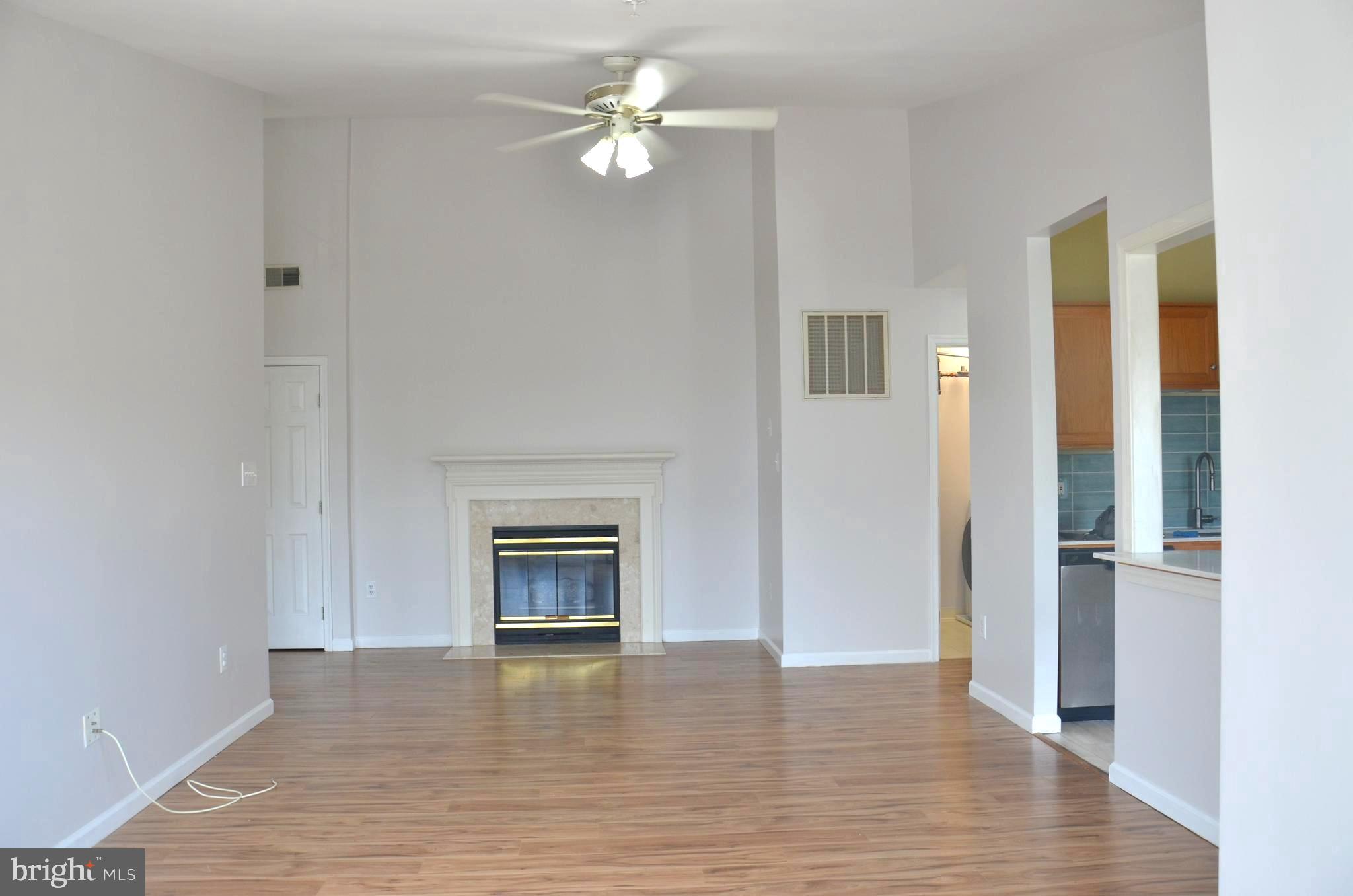 7522 Snowpea Court, Unit 24 Alexandria, VA 22306 - Photo 6 of 19 an empty room with a fireplace and wooden floor