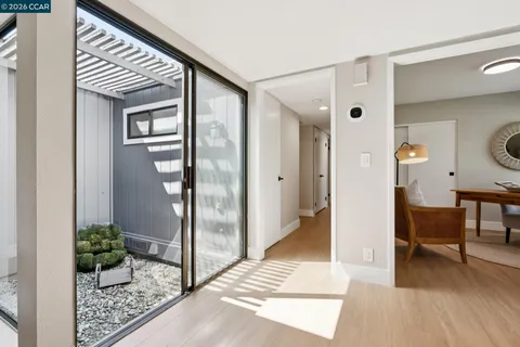 a view of a hallway with dining area and glass door