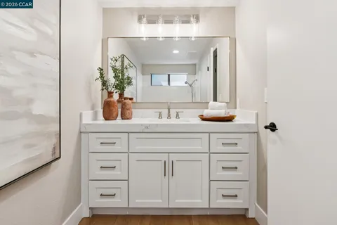 a bathroom with a sink vanity granite and a mirror