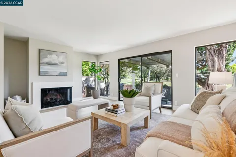 a living room with furniture a fireplace and a large window