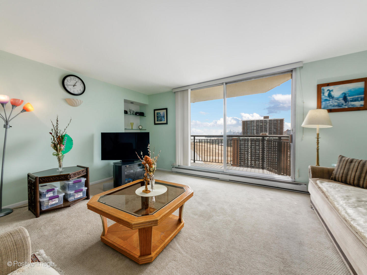6007 North Sheridan Road, Unit 17G Chicago, IL 60660 - Photo 3 of 18 a living room with furniture a flat screen tv and a floor to ceiling window