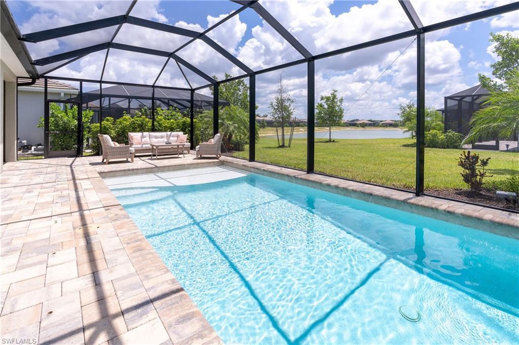 14488 Stillwater Way Naples, FL 34114 - Photo 12 of 36 Swimming pool featuring a lawn and a lanai
