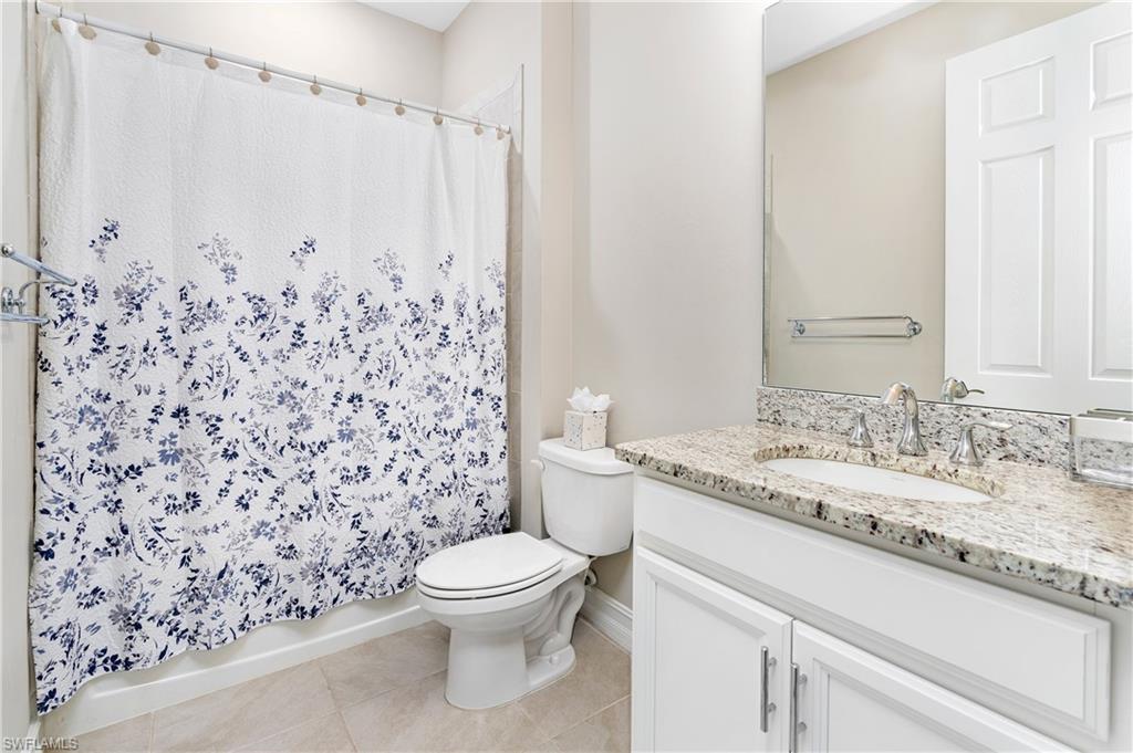 14488 Stillwater Way Naples, FL 34114 - Photo 23 of 36 Bathroom with vanity, light tile patterned flooring, and shower / bath combo with shower curtain
