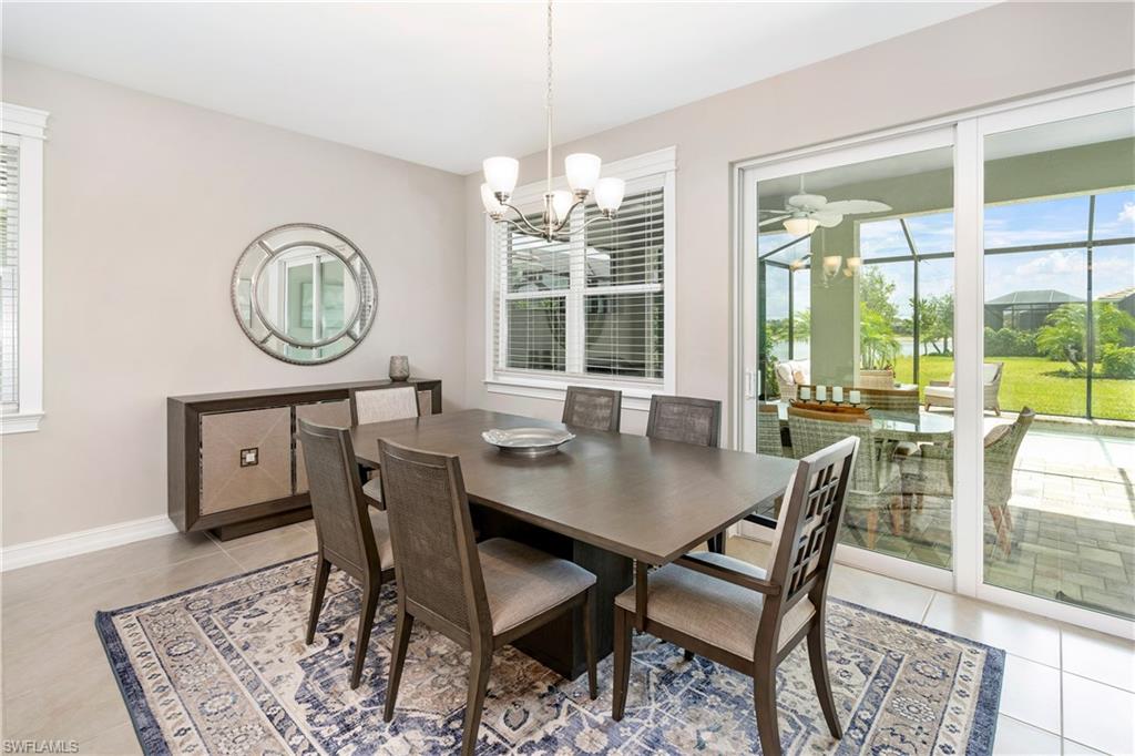14488 Stillwater Way Naples, FL 34114 - Photo 9 of 36 Dining room with healthy amount of natural light, light tile patterned floors, and a chandelier