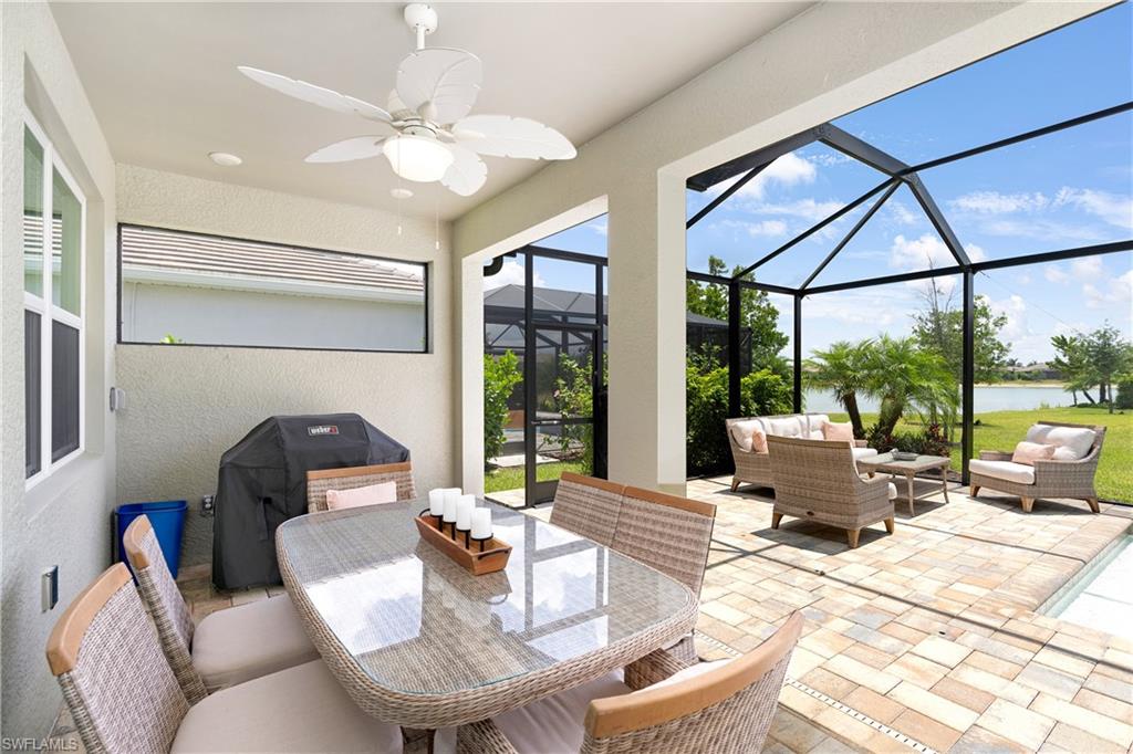 14488 Stillwater Way Naples, FL 34114 - Photo 10 of 36 View of patio featuring a ceiling fan, a water view, a sunroom, glass enclosure, and an outdoor hangout area