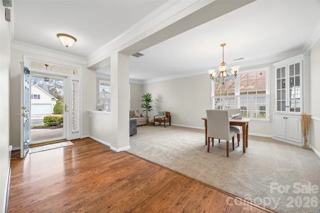a dining room with furniture a livingroom view and wooden floor