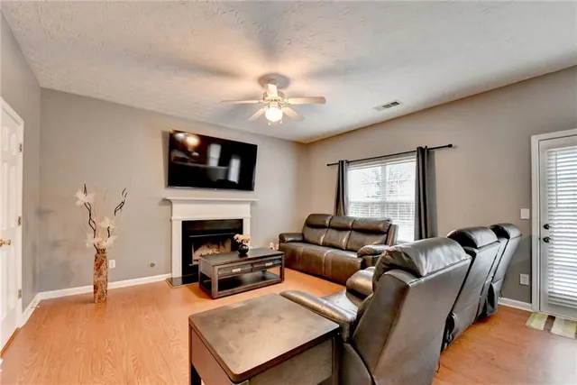a living room with furniture a fireplace and a flat screen tv